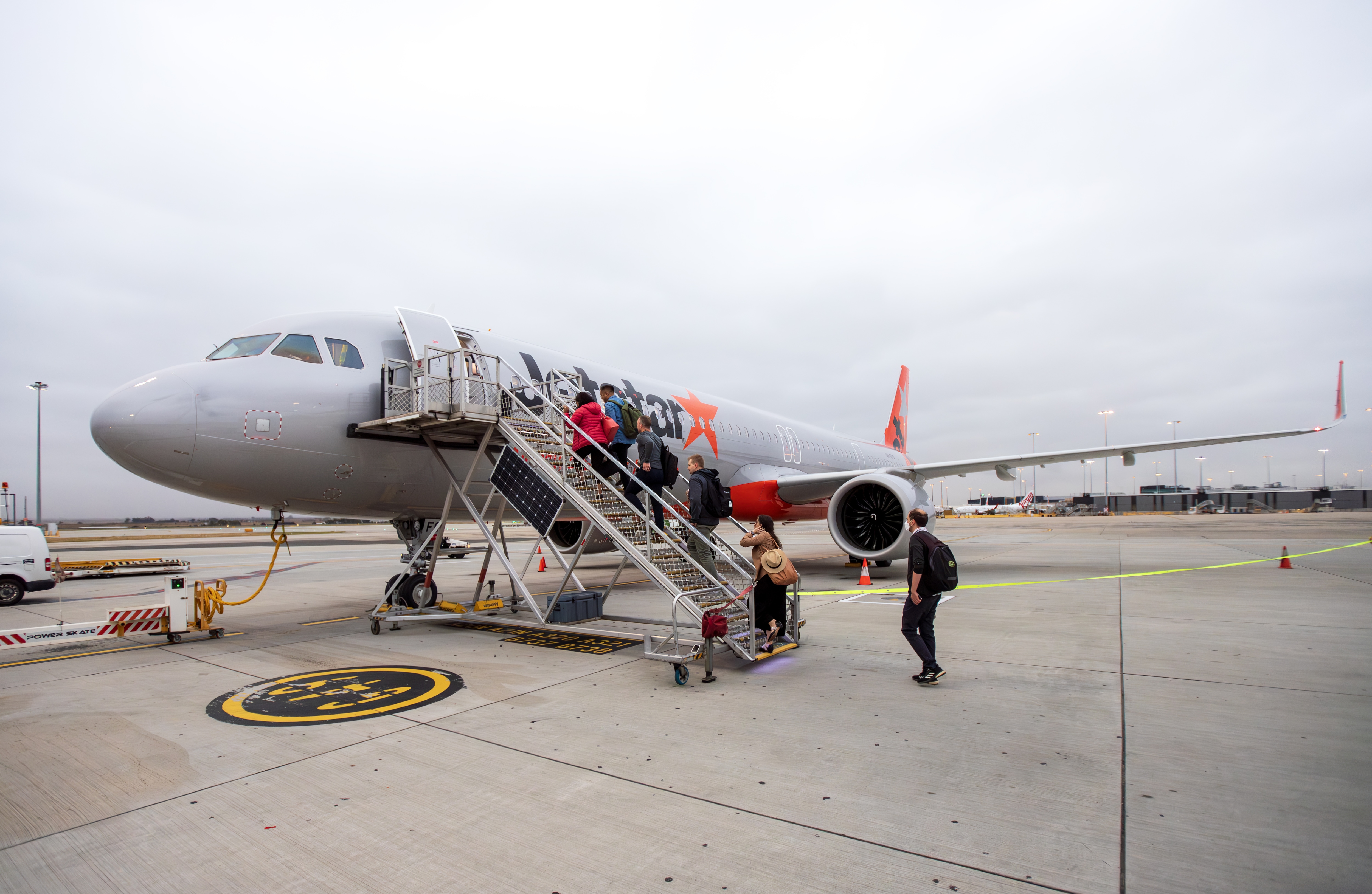 Passengers boarding a Jetstar aircraft via stairs